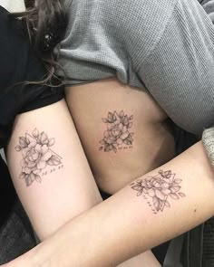 two women with tattoos on their stomachs, one has a flower and the other has a heart