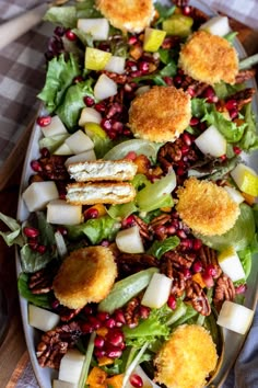 a salad with apples, cranberries and other toppings on a platter