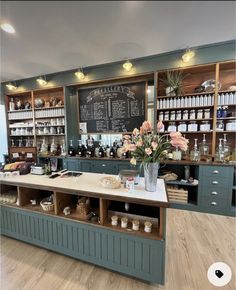 the inside of a coffee shop with lots of counter space and flowers in vases