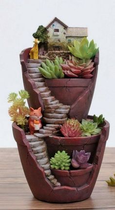 three tiered planters with succulents in them on a wooden table