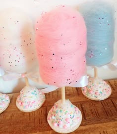 three different colored sprinkles are on top of cotton balls and stand next to each other