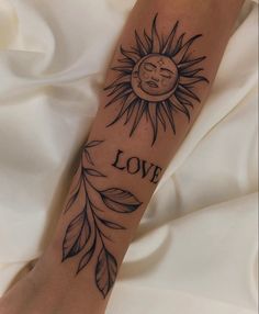 a person with a sun tattoo on their arm and the words love written in spanish