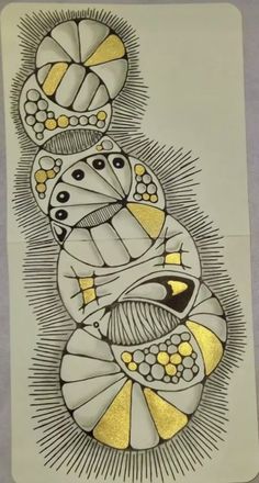 an artistic drawing on paper with gold and white designs in the shape of three circles