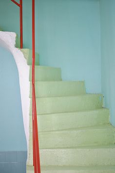 there is a cat that is sitting on the stairs in this room and it looks like he's waiting for something to happen