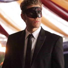 a man in a suit and tie with a blindfolded eye on his face