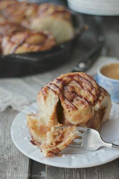 a cinnamon roll on a plate with a fork