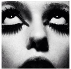 a black and white photo of a woman's face with long lashes on it