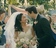 a bride and groom smile as they walk down the aisle