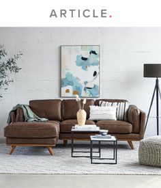 a living room filled with furniture next to a white brick wall and a painting on the wall