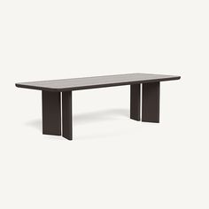 a black table sitting on top of a white floor next to a gray wall or floor