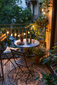 A small apartment balcony with a cozy seating nook featuring a round table and two chairs, adorned with potted plants and string lights. The balcony offers a picturesque view of a tree-lined street and neighboring buildings at sunset, creating a warm and inviting atmosphere. Tiny Balcony Inspiration, Apartment Patio Garden Ideas Tiny Balcony, Small Narrow Balcony Ideas, Fun Balcony Ideas, Tiny Terrace Ideas, Terrace Ideas Small Balcony Design, Cottagecore Balcony, Small Balcony Ideas On A Budget, Balkon Aesthetic