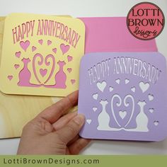 someone is holding up some happy anniversary cards