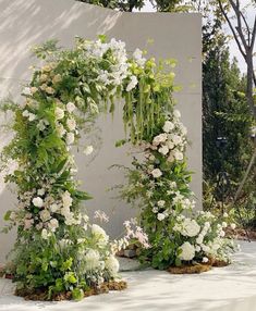 an outdoor wedding arch with flowers and greenery