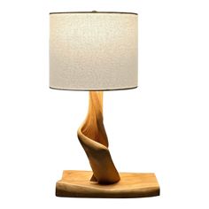 a wooden table lamp with a white shade on the base and a beige fabric lampshade