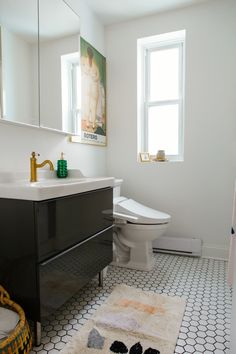 a bathroom with a toilet, sink and rug on the floor in front of it