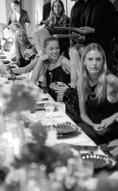 a group of women sitting at a table with plates and drinks in front of them