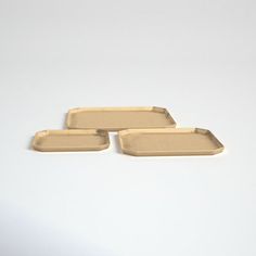 three empty trays sitting next to each other on a white surface with no one around them