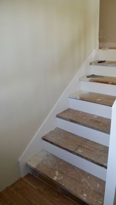 a set of white stairs with wood treads