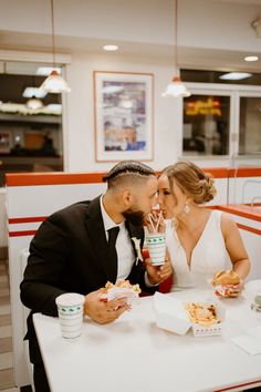 a man and woman sitting at a table eating food