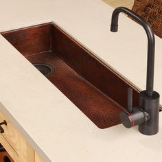 a sink and faucet in a kitchen with white counter tops, wooden cabinets and drawers