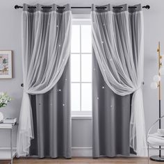 a living room with white curtains and grey drapes