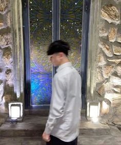 a man standing in front of a door with an artistic glass design on it's side