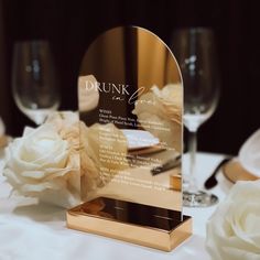 a glass award sitting on top of a table next to white flowers and wine glasses