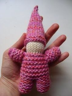 a hand holding a small knitted toy