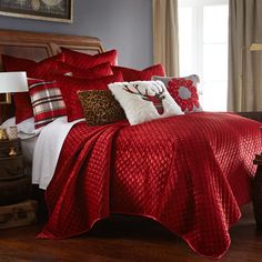 a bed with red comforter and pillows in a room