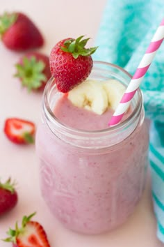 a strawberry banana smoothie in a mason jar with strawberries on the side