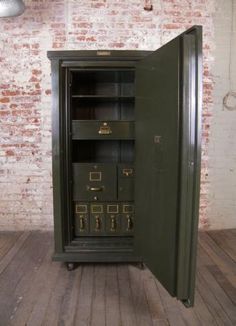 an open metal cabinet in front of a brick wall