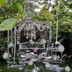 an outdoor table and chairs are set up in the garden for a wedding party or celebration