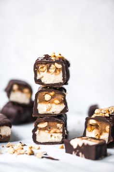 several pieces of chocolate with nuts and marshmallows stacked on top of each other