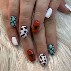 a woman's hand with different colored nail polishes on her nails and an animal print