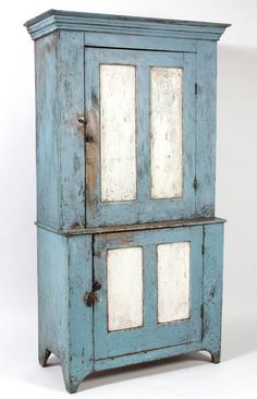 an old blue cabinet with white glass doors