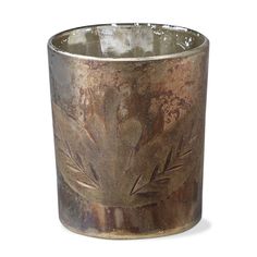 an old metal cup with leaves on it