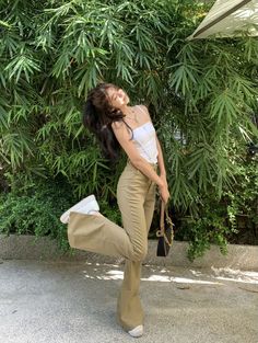 a woman is posing in front of some trees