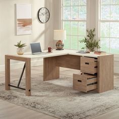 an office desk with drawers and a laptop on it in front of a large window