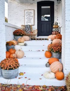 pumpkins and gourds are sitting on the front porch for fall decorating