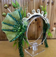 a decorative mirror with green and gold decorations on it's face, sitting on a table