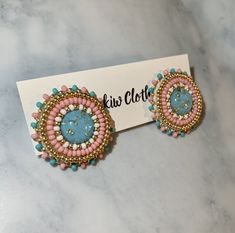 two pairs of pink and blue beaded earrings on top of a white card that says kiwi cloth