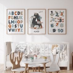 a baby's room with three posters on the wall and two children's chairs