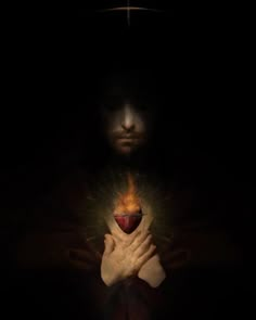 a man holding a heart in his hands with the light coming from it's center