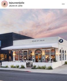 the exterior of a restaurant with white walls and black trimmings, on a street corner