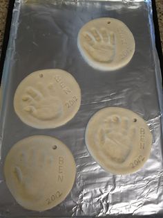 four hand prints on aluminum foil in the shape of cookies