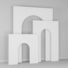 three pieces of white art sitting next to each other