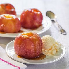 two white plates topped with apples covered in ice cream