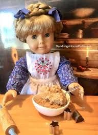 a doll is sitting at a table with some food