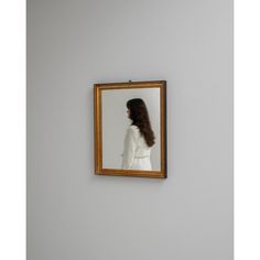 a woman's hair is reflected in a mirror on the wall next to a toilet