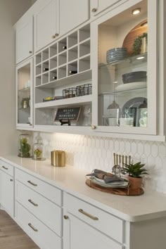 a kitchen with white cabinets and gold accents on the countertop, along with an oven